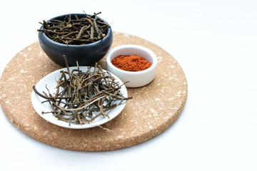 Fototapeta premium Saffron seasoning in root and powder, exhibited in containers on white wooden board