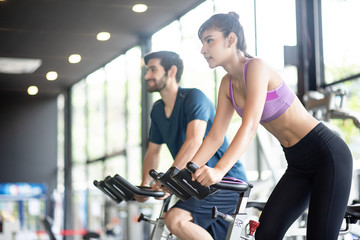 Young asian healthy woman bike cardio at the gym with smile and fresh face with her friend....