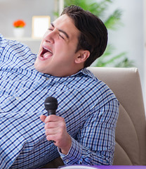Funny man singing songs in karaoke at home
