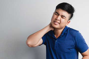 Man had neck pain with torture face in grey background. Healthy, Office syndrome, disease, illness,...