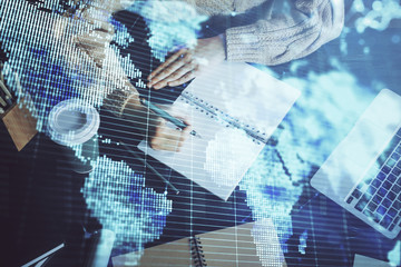 Obraz premium International business hologram over woman's hands taking notes background. Concept of success. Double exposure