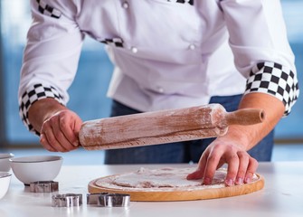 Young man cooking cookies in kitchen