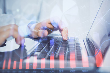 Double exposure of market chart with man working on computer on background. Concept of financial...