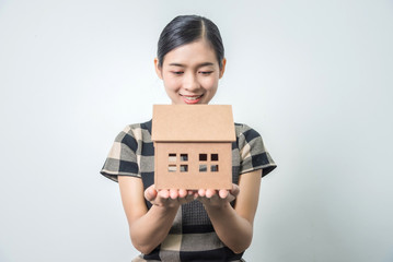 Young beautiful asian woman holding a house in her hands, black hairs.