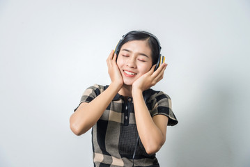 Beautiful young asian woman in headphones listening to music, shot in studio, black hair.