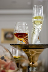 Close up of lot of glasses of fresh cognac and champagne on bar table. Party and holiday celebration concept