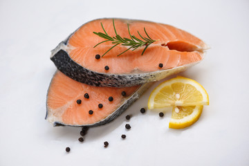 Fresh salmon steak on white plate  background - Raw salmon fish fillet for cooked steak seafood with herbs and spices lemon rosemary