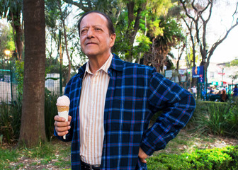A grandfather eating an ice cream in the park