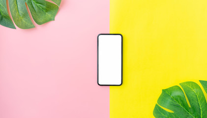 Top view with copy space and modern smartphone on pink and yellow color background. Summer holiday concept.