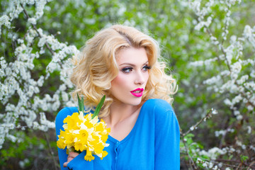 Naklejka premium Beautiful spring girl in blooming tree. Spring face fresh. Young beautiful woman make lipstick.
