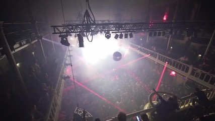Red light rays blinking at a techno event, crowd dancing and raising hands to music, at a nightclub, in Amsterdam, Netherlands