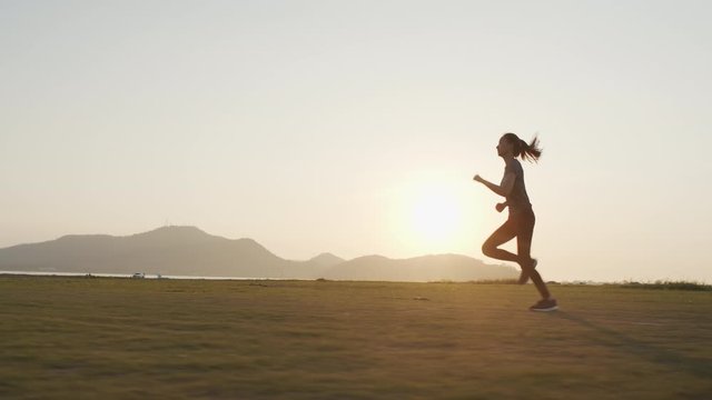 Young Asian women are exercising outdoor running with a mountain background. When the sunset or sunrise  in summer
