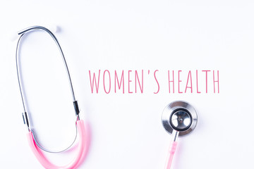 Pink stethoscope isolated on white with WOMEN’S HEALTH wordings