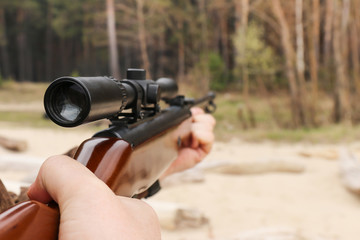 Air rifle with an optical sight in hand