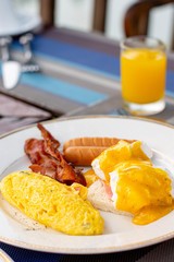 American breakfast with sunny side up eggs, bacon and juice