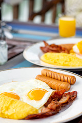 American breakfast with sunny side up eggs, bacon and juice