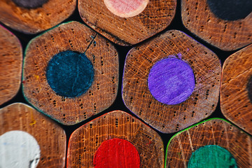Many wooden crayons that have been used in the dark background are macro images.