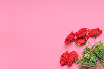 A layout of bouquet of red roses laying on a pink background, representing elegances copy space of gifts for Christmas, valentine’s day, happy birthday or any kind of special events that is red theme