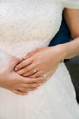 Close-up of a couple wearing a ring embracing each other.