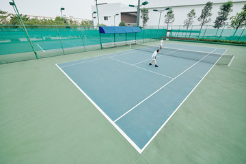 Friends renting outdoor court to play tennis on weekend