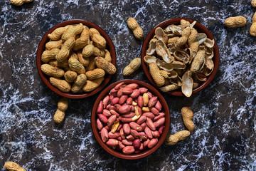 Two bowls with peanuts and one with shells