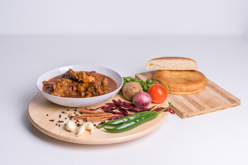 Hot and spicy Singapore's national dish the sup tulang made out of mutton bone marrow in a white bowl and white background