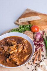 Hot and spicy Singapore's national dish the sup tulang made out of mutton bone marrow in a white bowl and white background