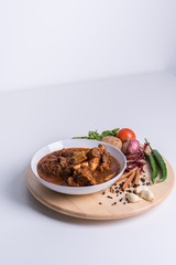 Hot and spicy Singapore's national dish the sup tulang made out of mutton bone marrow in a white bowl and white background