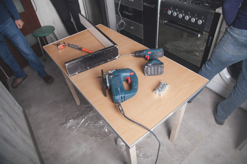 Electric saw and cordless screwdriver on the table. Industry, Housework