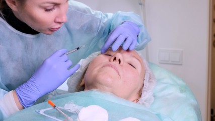 Obraz na płótnie Canvas Woman getting cosmetic injection, closeup. Woman in beauty salon. plastic surgery clinic