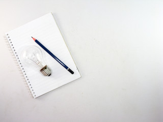 Light bulb and notebook with pencil On a white background , business planning concept, minimalist