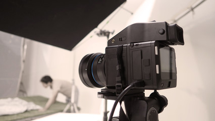 Studio medium format digital camera setup on tripod and professional equipment in studio with black and white color softbox and lighting set for still photo shooting or high resolution video or movie 