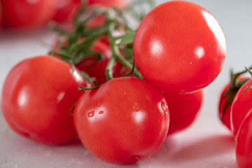Fresh, bright and juicy cherry tomatoes on a white table