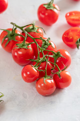 Fresh, bright and juicy cherry tomatoes on a white table