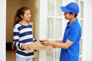 Happy young pretty Asian woman receiving pizza she ordered online