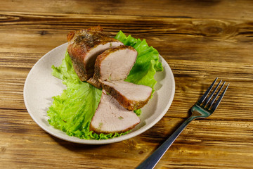 Tasty baked pork with spices on a wooden table