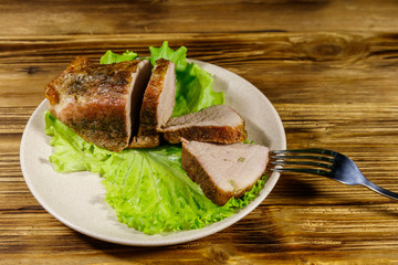 Tasty baked pork with spices on a wooden table