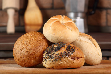 Assortment of bread rolls at rural kitchen background