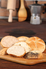 Assortment of sliced bread rolls at rural kitchen background