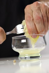 Juice lemon half with assistance of fork. Making Lemon Mascarpone Pie Series.