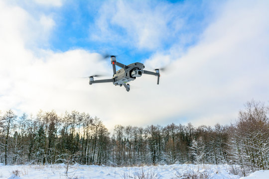 A quadcopter with a built-in camera flies into the sky, captures video footage of the photo.