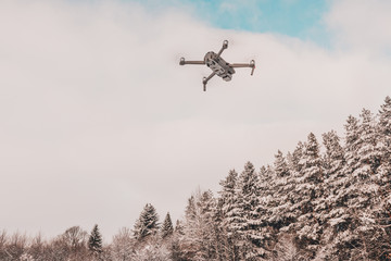 Fototapeta na wymiar The drone flies in the winter above the forest and shoots landscape videos.