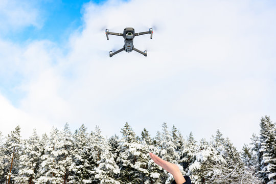 The drone flies in the winter above the forest and shoots landscape videos.