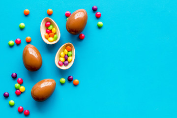 Chocolate eggs - Easter symbol - frame on blue background top-down copy space