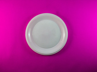 White plate on bright pink background