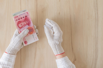 Obraz na płótnie Canvas Chinese female hand in protective from coronavirus (virus) gloves counting money of south-east Asia. Сhina yuan (CNY) Currency of Hong Kong, Indonesia, Malaysia, Thai, Singapore dollar.