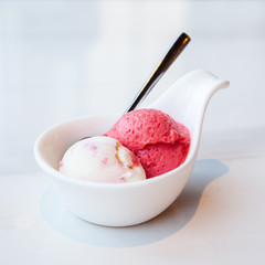 Raspberry and yogurt ice cream served on mini white bowl