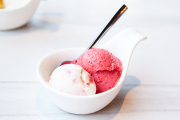 Raspberry and yogurt ice cream served on mini white bowl