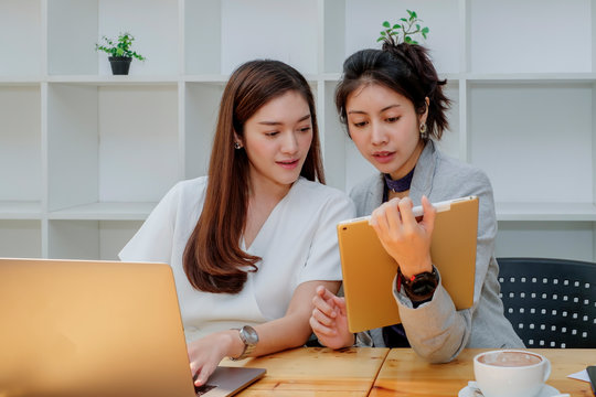 Asian young business woman and designer working in project, co-working and brainstoming, using tablet application for presentation