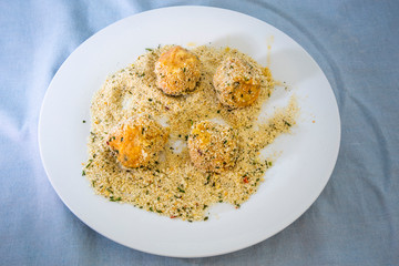 Roll the arancini ball in the breadcrumbs
